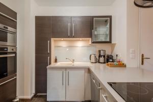 a white kitchen with a sink and a microwave at Agora by Kleidos - Bel appartement T3-6 personnes, Disney 10 mn, parking gratuit in Magny-le-Hongre
