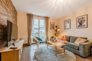 a living room with a couch and a tv at Agora by Kleidos - Bel appartement T3-6 personnes, Disney 10 mn, parking gratuit in Magny-le-Hongre