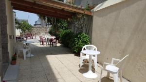 a patio with white chairs and tables on a sidewalk at AN ABER Hôtel Café in Lannilis