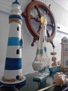 ein Leuchtturm und ein Holzboot auf einem Tisch in der Unterkunft Le Vele in Salerno