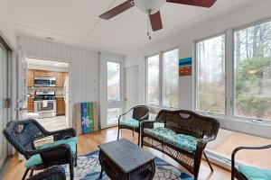 a living room with chairs and a ceiling fan at Teal Haven in Ocean Pines