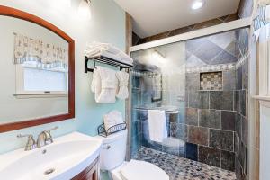 a bathroom with a shower and a toilet and a sink at Teal Haven in Ocean Pines +26 photos