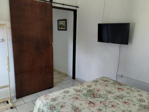 a bedroom with a bed and a flat screen tv at Cantinho da Paz in Socorro