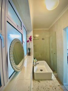 a bathroom with a sink and a mirror at Watching Waves, Heron Chase in Fish hoek