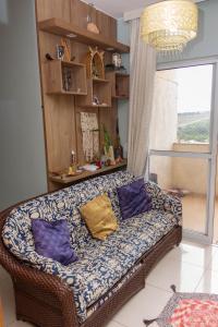 a living room with a couch with pillows on it at Quarto Residencial Dubai - Lazer Completo in Brasília +23 photos