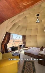 a room with a bed and a large window at Traditions of Wadi Rum camp & jeep tour in Wadi Rum