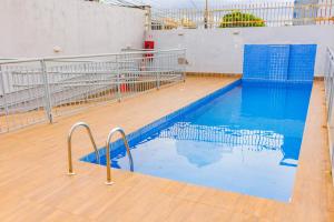 a swimming pool with blue water and a wooden floor at Quarto Residencial Dubai - Lazer Completo in Brasília
