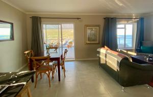 a living room with a table and a couch at Watching Waves, Heron Chase in Fish Hoek