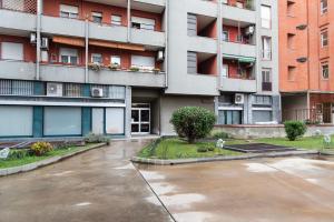 an empty parking lot in front of an apartment building at Youhosty - Paul Valery Bis in Milan