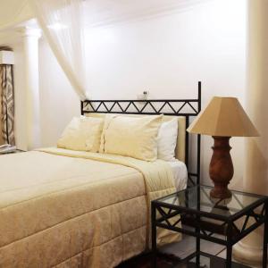 a bedroom with a bed and a table with a lamp at The Landmark Boutique Hotel in Blantyre +4 photos