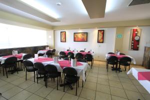 a dining room with red and white tables and chairs at Hotel Estadio in Guadalajara