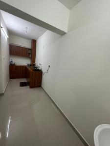 an empty room with a sink and a kitchen at Platinum PAL suits in Nedumbassery