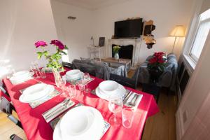a dining room table with a red table cloth at Harrods Flats in London