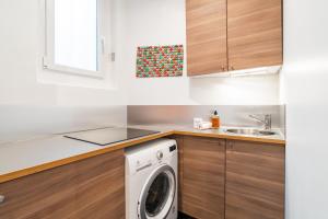 una cocina con lavadora y fregadero en Appartement cosy à 2 min de Paris 16 ème, en Boulogne-Billancourt