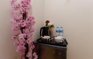 a table with a coffee maker and a tree with pink flowers at Pyramids Art Inn in Cairo +76 photos