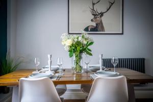 a dining room table with chairs and a vase of flowers at Walmgate Cottage in York