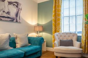 a living room with a blue couch and a chair at Walmgate Cottage in York