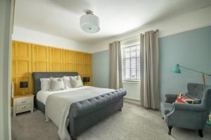a bedroom with a bed and a chair at Walmgate Cottage in York