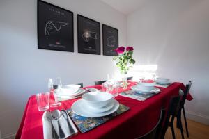 a table with a red table cloth and plates and glasses at Harrods Flats in London