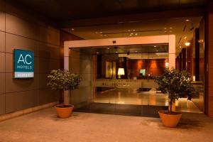 a building with two potted plants in front of a store at AC Hotel Guadalajara by Marriott, Spain in Guadalajara