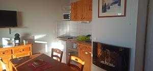 a small kitchen with a table and a dining room at Chamrousse - Résidence La Grive in Chamrousse