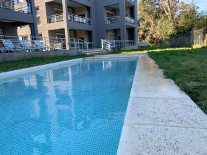 a swimming pool in front of a building at Newen Pinamar in Pinamar