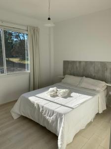 a white bed in a bedroom with a window at Newen Pinamar in Pinamar +51 photos