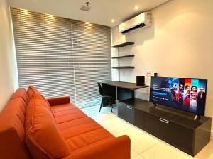 a living room with an orange couch and a desk at Casa Ipê - Beira lago- Lake View in Brasília