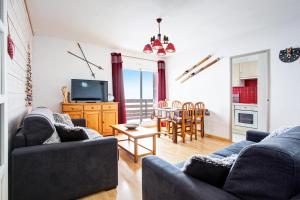 a living room with two couches and a dining room at Soleil et Montagne - Au pied station les Angles in Les Angles
