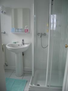 a white bathroom with a sink and a shower at No 1 Broughton Bed & Breakfast in Pierowall