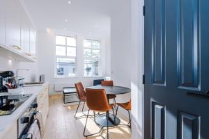 a kitchen with a table and chairs and a blue door at Stylish 1-Bedroom Getaway in Sale in Sale