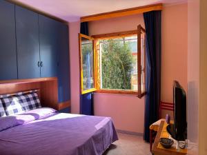 a bedroom with a bed and a window at Villa Atlante in Bibione