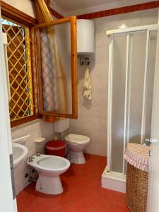 a bathroom with a toilet and a sink and a shower at Villa Atlante in Bibione