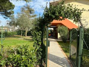 a garden with a green gate and a building at Villa Atlante in Bibione