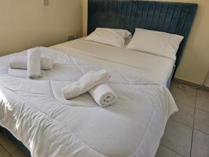 ein Bett mit zwei weißen Handtüchern darauf in der Unterkunft Two bedroom holidays apartment, walking distance to the beach and Harbour in Paphos