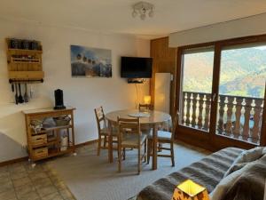 salon ze stołem i krzesłami oraz balkonem w obiekcie 3 pièces skis aux pieds avec balcon à Saint-Jean-d'Aulps - FR-1-573-80 w mieście Saint-Jean-dʼAulps