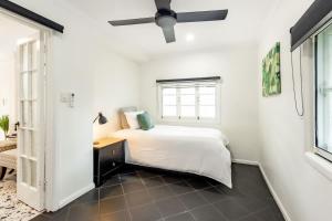 a bedroom with a bed and a ceiling fan at Bluebell Charm Cairns 4BR Home, 3 min to Hospital in Cairns North
