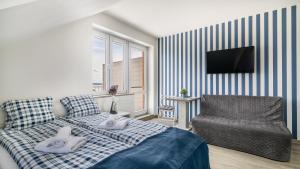 a bedroom with a bed and a chair and a television at Surf camp in Krynica Morska