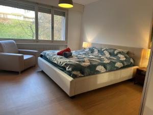 una camera da letto con un letto, una sedia e una finestra di Lovely room, 15 min from center, mountain view a Zurigo