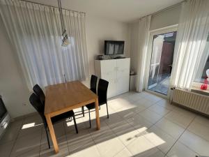 a dining room with a wooden table and chairs at Heimathafen in Norddeich