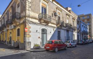 Un coche rojo aparcado delante de un edificio en Awesome Apartment In Catania With Wifi, en Catania