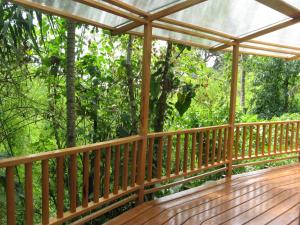 une terrasse en bois avec une pergola dans les bois dans l'établissement Pacoche Lodge, à Pacoche