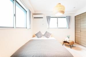 a bedroom with a large bed and two windows at Degere in Tokyo