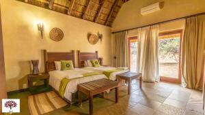 a bedroom with a bed and a large window at Zebula Golf and Wildlife Estate - Oryx Walkway Pax 16 - Moi Signature Luxury villa in Mabula +31 photos