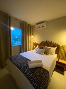a bedroom with a large bed with a window at Recanto dos Corais in Marau
