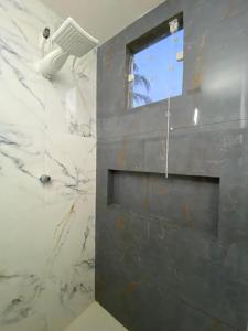 a bathroom with a stone wall with a window at Recanto dos Corais in Marau +3 photos