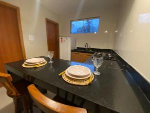 a kitchen with a counter with plates and glasses on it at Recanto dos Corais in Marau +3 photos