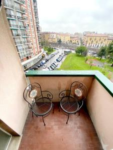 two benches on a balcony with a view of a parking lot at "Suite Sesto" Metro M1 to Milano, Rho Fiera, Monza in Sesto San Giovanni