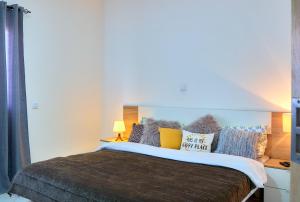 Un dormitorio con una cama grande con muchas almohadas en Super Cozy One-Bedroom Apartment, en Santa Maria