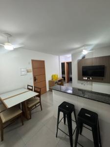 Apartamento vista mar 72 في برايا جراندي: غرفة معيشة مع طاولة و كرسيين